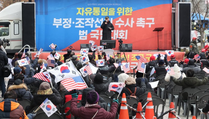 지난 16일 서울 종로구 동화면세점 앞에서 열린 보수 단체 주최 탄핵 반대 집회에서 참가자들이 태극기와 성조기를 흔들고 있다. 사진=뉴시스화상