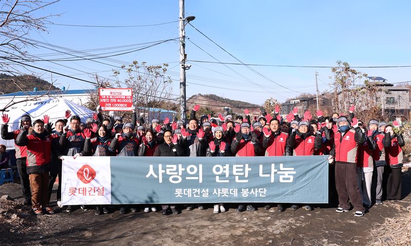 지난 18일 롯데건설 임직원들이 서울 서초구 남태령 전원마을을 찾아 '사랑의 연탄 나눔' 봉사를 진행한뒤 기념촬영을 하고 있다. 롯데건설 제공