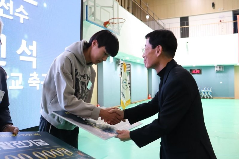 체육 장학금을 기부하고 있는 강 대표. (오른쪽). /뉴스1