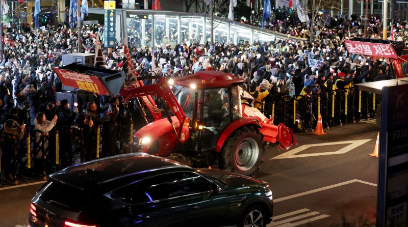 [서울=뉴시스] 김진아 기자 = 윤석열 대통령 구속을 촉구하며 트랙터 상경 시위에 나선 전국농민회총연맹 전봉준투쟁단의 트랙터가 22일 오후 서울 용산구 한강진역을 지나 시민들의 환호를 받으며 대통령 관저로 향하고 있다. 2024.12.22. bluesoda@newsis.com