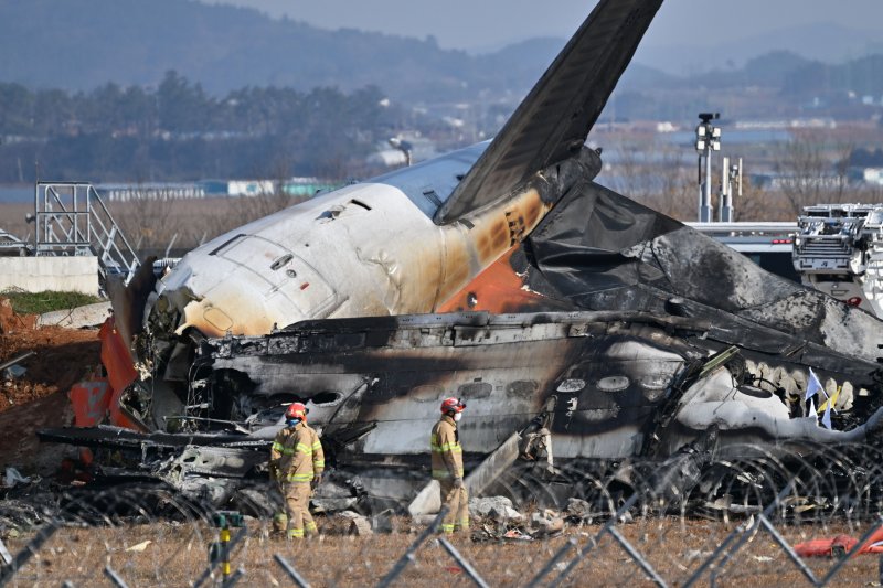 [무안=뉴시스] 이영주 기자 = 전남 무안공항에서 여객기 착륙 도중 충돌 사고가 난 29일 오후 소방 당국이 여객기 잔해를 살피고 있다. 2024.12.29. leeyj2578@newsis.com /사진=뉴시스