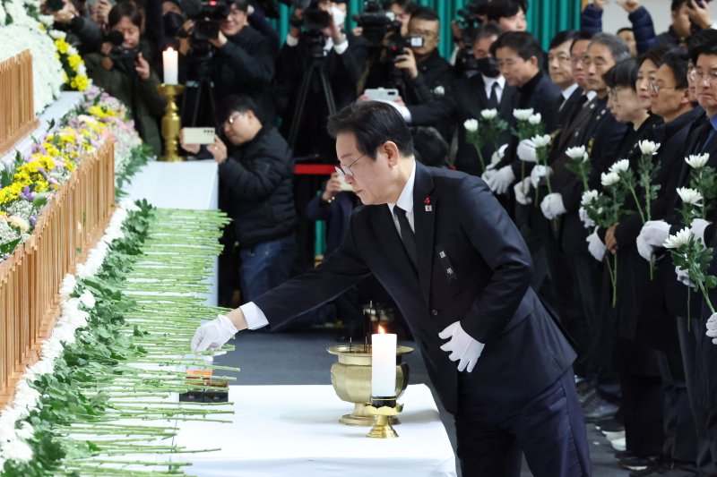 [무안=뉴시스] 이영주 기자 = 이재명 더불어민주당 대표가 30일 전남 무안 스포츠파크에 차려진 제주항공 여객기 참사 합동 분향소에서 헌화를 하고 있다. (공동취재) 2024.12.30. photo@newiss.com