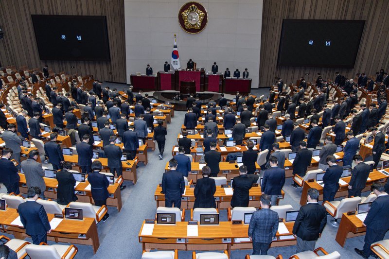 우원식 국회의장을 비롯한 여야 의원들이31일 오후 서울 여의도 국회 본회의장에서 열린 제420회 국회(임시회) 제3차 본회의에서 무안 제주항공 사고 희생자를 기리며 묵념하고 있다. 뉴스1