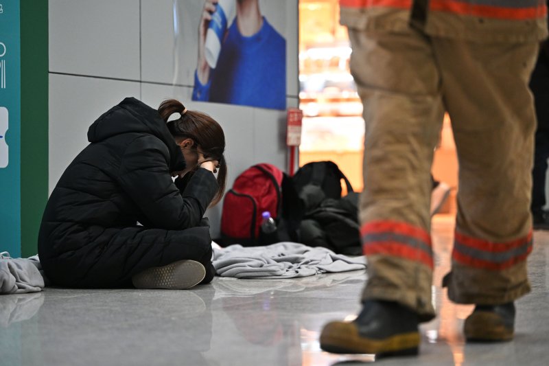 [무안=뉴시스] 이영주 기자 = 제주항공 소속 여객기 착륙 도중 충돌 사고 이튿날인 30일 오전 전남 무안군 무안국제공항 2층 대합실에서 한 유족이 주저앉아 머리를 붙잡고 있다. 2024.12.30. leeyj2578@newsis.com