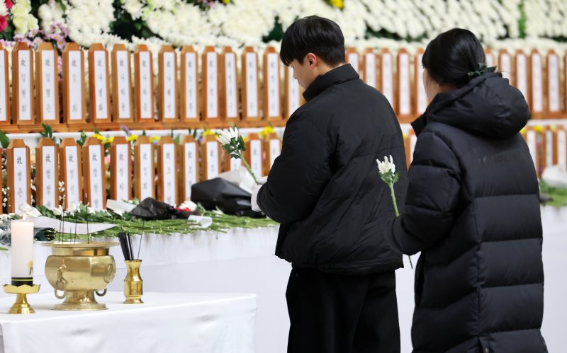 지난해 12월 29일 전남 무안국제공항에서 발생한 제주항공 여객기 참사로 사망한 179명 전원의 신원이 확인됐다. 사진은 2025년 첫날인 1일 전남 무안군 무안스포츠파크에 마련된 정부합동분향소에서 시민들이 헌화하고 있는 모습. 연합뉴스 제공