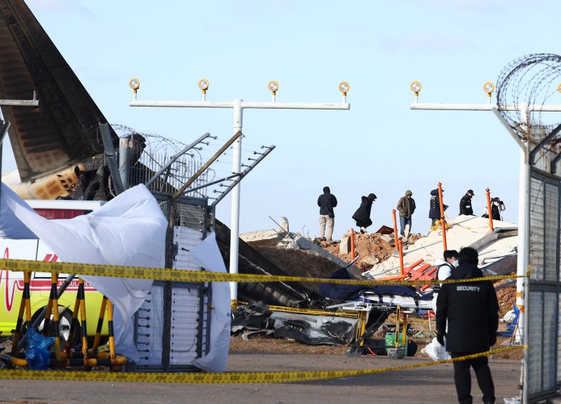 31일 오후 전남 무안국제공항 제주항공 여객기 참사 현장에서 미국 연방항공청, 교통안전위원회, 보잉 등 한미합동조사 관계자들이 사고 여객기와 충돌로 부서진 방위각 시설(로컬라이저) 등을 조사하고 있다. 2024.12.31/뉴스1 ⓒ News1 김민지 기자