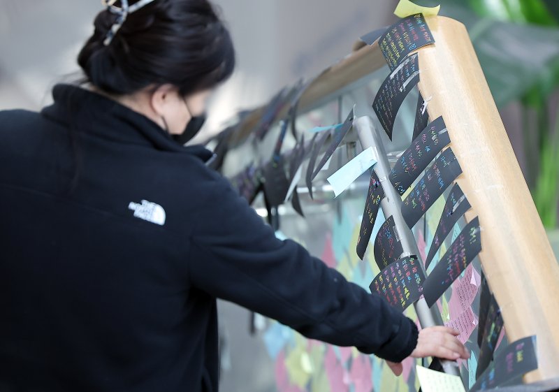 제주항공 여객기 참사 엿새째인 3일 전남 무안군 무안국제공항 대합실 계단에서 한 유가족이 희생자를 추모하는 글귀를 바라보고 있다. 2025.1.3/뉴스1 ⓒ News1 김진환 기자