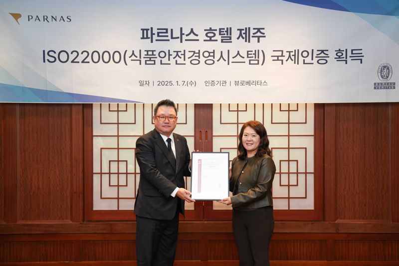식품안전경영시스템 ISO 22000 국제인증 수여식에서 김호경 파르나스 호텔 제주 총지배인(왼쪽)과 연봉조 한국뷰로베리타스 대표이사가 기념촬영을 하고 있다.