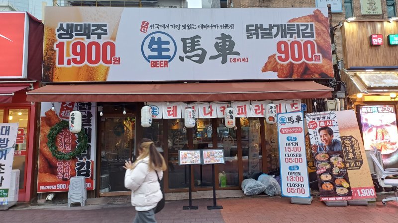 지난 5일 서울 홍대입구역 근처에서 '1900원 맥주'를 파는 '생마차' 가게 앞으로 한 시민이 지나가고 있다. 사진=이환주 기자