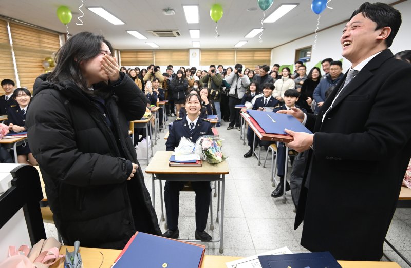 [수원=뉴시스] 김종택 기자 = 8일 경기도 수원시 삼일공업고등학교에서 열린 졸업식에서 경찰사무행정과 졸업생이 담임선생님으로부터 졸업장과 졸업 앨범을 전달 받으며 울먹이고 있다. 2025.01.08. jtk@newsis.com