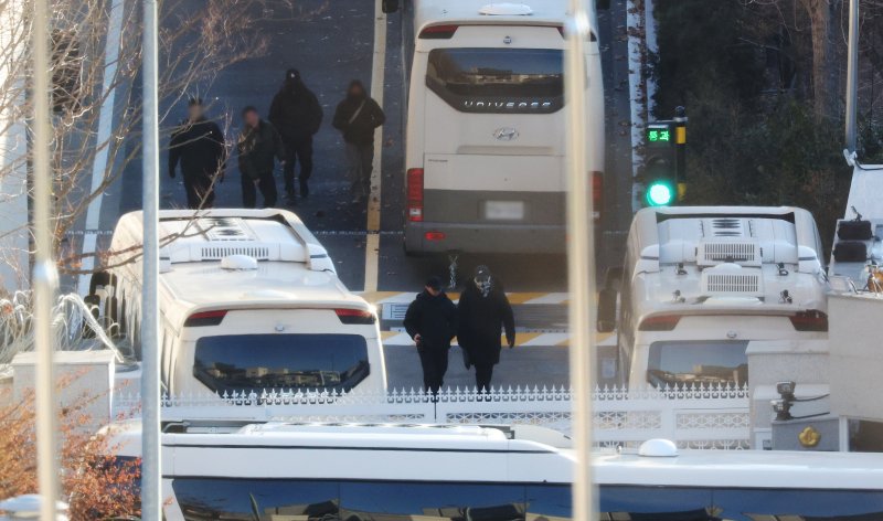 내란수괴 혐의를 받는 윤석열 대통령에 대한 체포영장이 재발부된 가운데 9일 오전 서울 용산구 한남동 대통령 관저에서 차벽을 세우기 위해 동원된 버스 차량 옆으로 경호처 등 관계자들이 이동하고 있다. 2025.1.9/뉴스1 ⓒ News1 장수영 기자