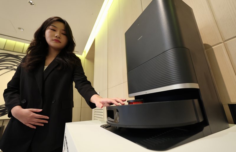 15일 서울 종로구 포시즌스호텔에서 열린 신제품 출시 기자간담회에서 직원이 신제품 로봇청소기(X20 맥스)를 살펴보고 있다. 샤오미코리아는 이날 스마트폰 2종(샤오미 14T, 레드미노트 14 프로 5G)과 샤오미 TV시리즈, 스마트워치(레드미 워치5), 로봇청소기(X20 맥스)등을 신제품으로 공개했다. 2025.1.15/뉴스1 ⓒ News1 김도우 기자