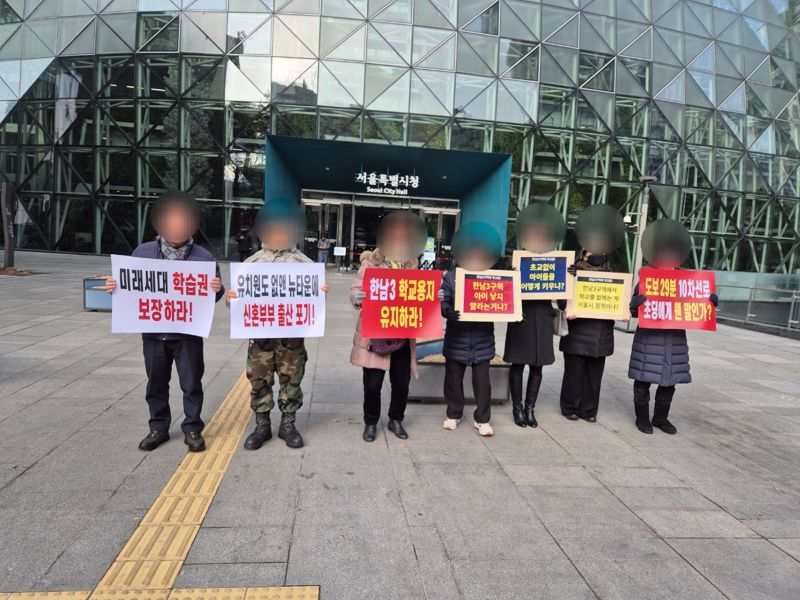 한남3재정비촉진구역 재개발사업 조합 관계자들이 지난 14일 서울시청을 찾아 피켓시위에 나섰다. 서울시가 사업장 내 초등학교 용지를 공공공지로 변경하는 데 대한 문제 제기다. 독자 제공