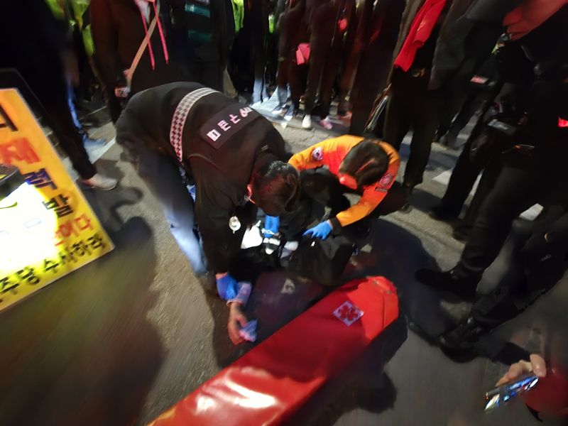 17일 오후 6시10분께 서울 공덕동 서울 서부지법 앞에서 윤석열 대통령 지지자 중 한 명이 고위공직자범죄수사처의 구속영장 청구에 항의하다 쓰러져 구급차로 옮겨지고 있다. /사진=서지윤 기자