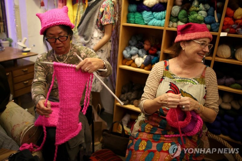 2017년 1월 13일 캘리포니아주 로스앤젤레스에서 '여성들의 행진' 참가자들에게 줄 분홍 고양이 모자를 뜨고 있는 여성들 (출처=연합뉴스)