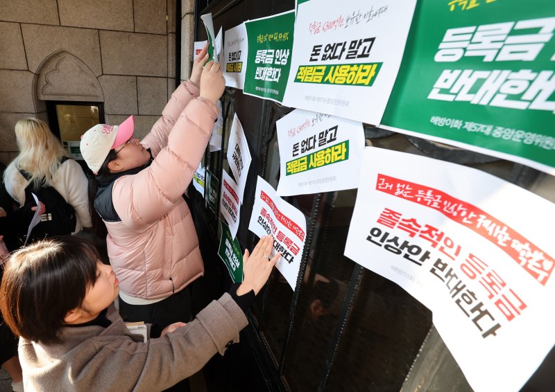 [서울=뉴시스] 이영환 기자 = 이화여자대학교 학생들이 17일 오후 서울 서대문구 이화여자대학교 정문에서 등록금 인상 반대하는 이화인 3239인 서명 전달 기자회견을 마친 후 본관으로 행진해 문이 닫혀 있자 피켓을 붙이고 있다. 2025.01.17. 20hwan@newsis.com