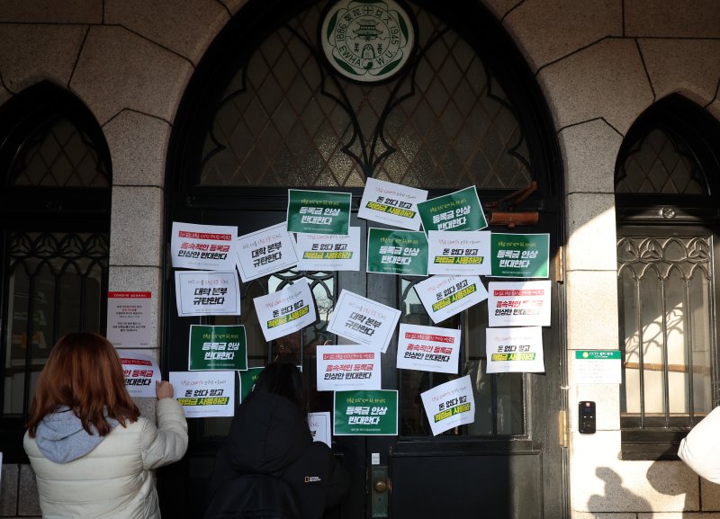 [서울=뉴시스] 이영환 기자 = 이화여자대학교 학생들이 17일 오후 서울 서대문구 이화여자대학교 정문에서 등록금 인상 반대하는 이화인 3239인 서명 전달 기자회견을 마친 후 본관으로 행진해 문이 닫혀 있자 피켓을 붙이고 있다. 2025.01.17. 20hwan@newsis.com