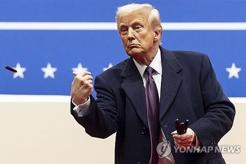 행정명령 서명에 쓴 펜을 지지자에게 던져주는 트럼프 (출처=연합뉴스)