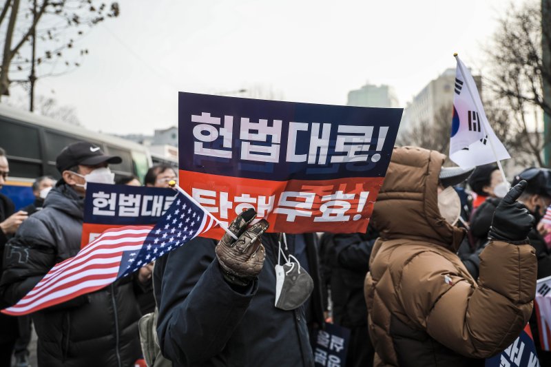 [서울=뉴시스] 정병혁 기자 = 윤석열 대통령에 대한 탄핵심판 3차 변론기일이 열린 21일 서울 종로구 헌법재판소 인근에서 열린 탄핵 반대 집회에서 참가자들이 태극기와 성조기를 들고 구호를 외치고 있다. 2025.01.21. jhope@newsis.com