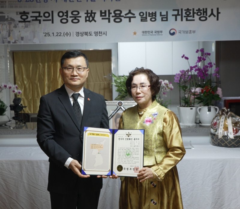 이근원 국방부 유해발굴감식단장(왼쪽)이 22일 경북 영천시에 위치한 고(故) 박용수 일병 유가족 자택에서 열린 호국의 영웅 귀환 행사에서 전사자 확인 통지서를 전달하고 있다. 국군 제8사단 소속 고 박 일병은 6·25전쟁 당시 조국을 지키다 21세의 나이로 전사했다. 사진=국방부 제공