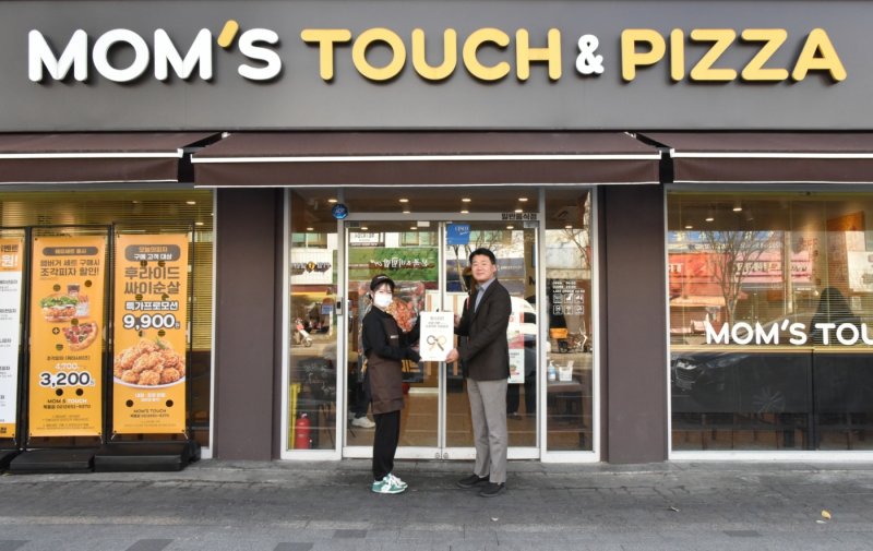 맘스터치 목동점에서 열린 최우수 매장 현판식에서 이진영 맘스터치앤컴퍼니 가맹사업실장(오른쪽)과 이서영 맘스터치 목동점 점주가 기념촬영을 하고 있다. (사진=맘스터치 제공) *재판매 및 DB 금지