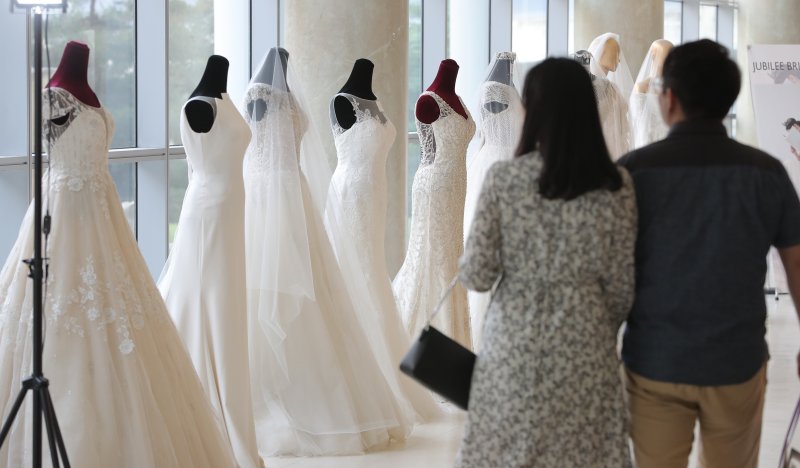 2019년 서울의 한 호텔에서 열린 웨딩 박람회를 찾은 예비 부부가 드레스 등 결혼 관련 상품을 둘러보고 있다. 2019.5.26/뉴스1 ⓒ News1 구윤성 기자