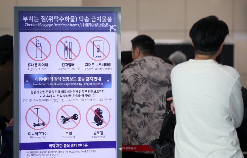 김해공항에서 발생한 에어부산 화재가 기내 선반에서 시작됐다는 목격자의 증언이 잇따르면서 휴대용 보조배터리가 화재 원인일 가능성이 제기되고 있는 가운데 30일 부산 강서구 김해국제공항 국제선 출국장에 설치된 부치는 짐(위탁수하물) 탁송 금지물품을 안내하는 전광판에 휴대폰 보조배터리 등이 표시돼 있다. 2025.1.30/뉴스1 ⓒ News1 윤일지 기자