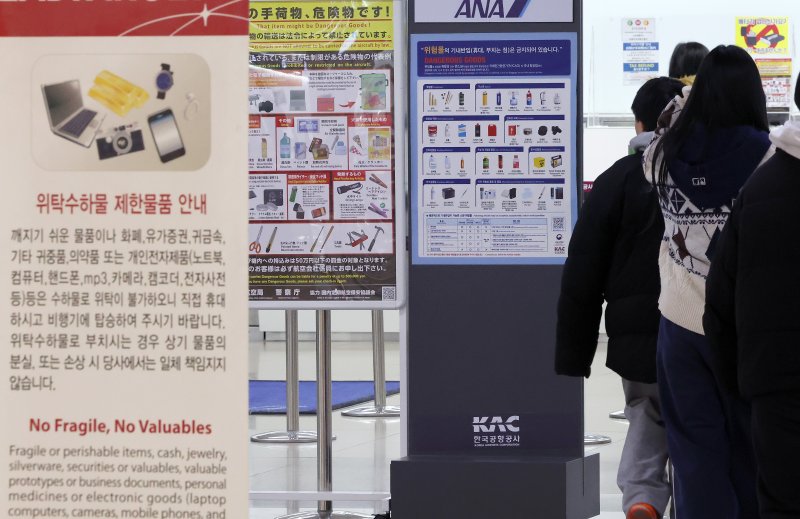 30일 서울 강서구 김포국제공항 국제선 탑승수속 층에 배터리 등 기내반입 금지 물품이 적힌 안내판이 붙어 있다. 지난 28일 김해공항에서 발생한 에어부산 여객기 화재의 원인으로 기내 선반에 실려있던 수화물이 지목되는 가운데, 보조배터리로 인한 화재일 가능성에 관심이 쏠리고 있다. 항공 위험물 운송기준에 따르면 리튬 메탈 배터리와 리튬 이온 배터리는 위험물로 분류돼 기내 휴대나 위탁수하물 반입이 기본적으로 금지된다. 국내외 항공기에서 배터리가 원인으로 추정되는 화재가 잇따르면서 기내 반입 물품에 대한 규정 강화를 요구하는 목소리도 커