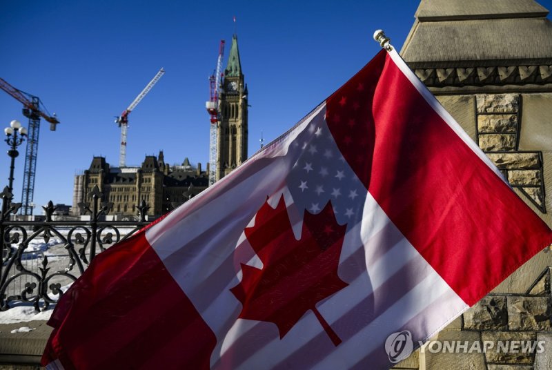 캐나다와 미국 국기를 겹쳐들고 시위를 벌이는 캐나다인들 (출처=연합뉴스)