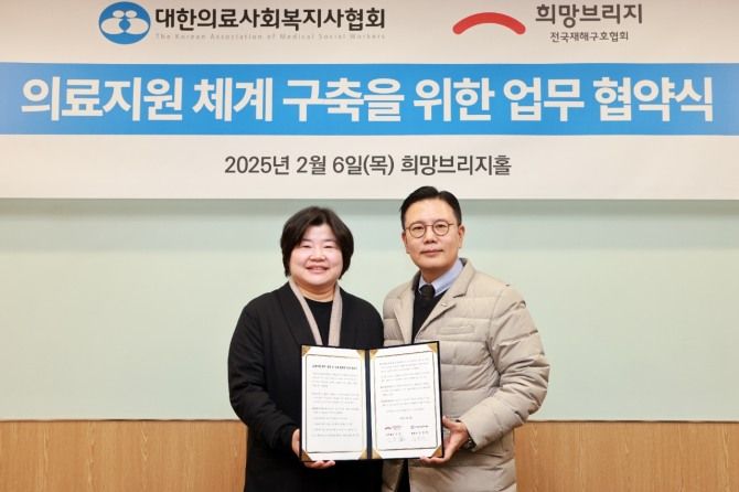 신훈 희망브리지 사무총장(오른쪽)이 김현희 대한의료사회복지사협회장과 업무협약식 진행 후 기념사진 촬영을 하고있다. 희망브리지 제공