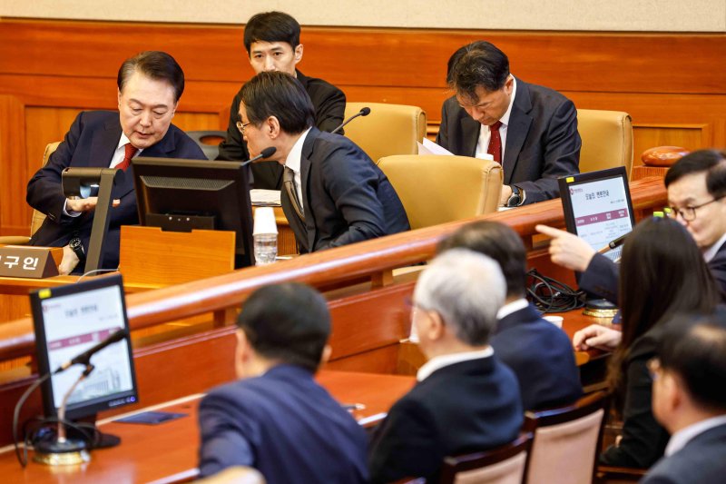 [서울=뉴시스] 사진공동취재단 = 윤석열 대통령이 11일 서울 종로구 헌법재판소에서 열린 '윤석열 대통령 탄핵심판 7차 변론'에 출석해 배보윤 변호사와 의견을 나누고 있다. 2025.02.11. photo@newsis.com