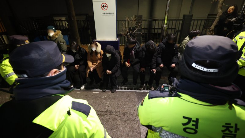 내란 우두머리 혐의로 체포된 윤석열 대통령의 영장실질심사가 열린 지난달 18일 오후 서울 마포구 서울서부지방법원에서 윤 대통령의 석방을 촉구하며 법원 담장을 넘어 들어온 청년들이 경찰에 붙잡혀 있다.(공동취재) 2025.1.19/뉴스1 ⓒ News1 민경석 기자