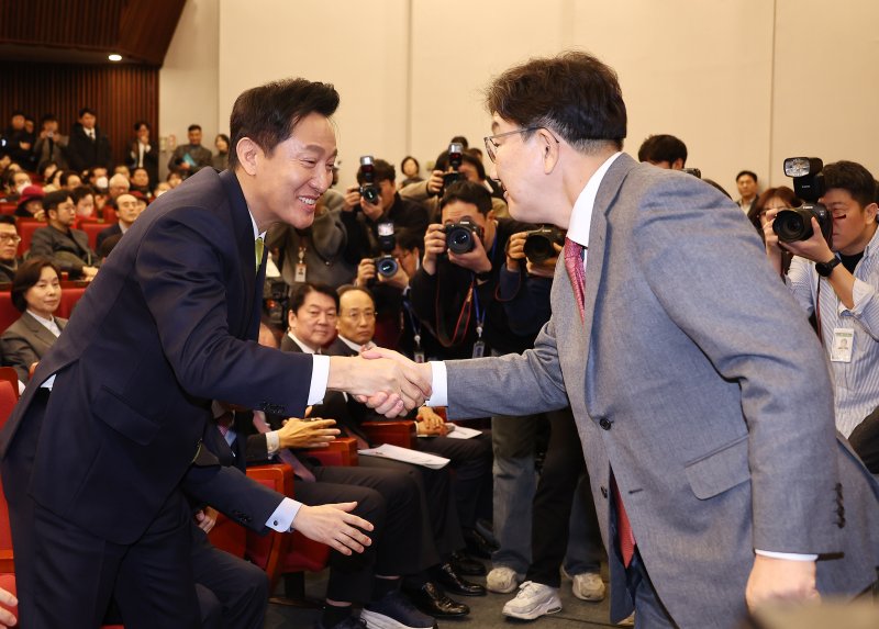 오세훈 서울시장이 12일 서울 국회 도서관에서 열린 '87체제 극복을 위한 지방분권 개헌 토론회'에서 축사를 마친 국민의힘 권성동 원내대표와 인사를 나누고 있다. 연합뉴스