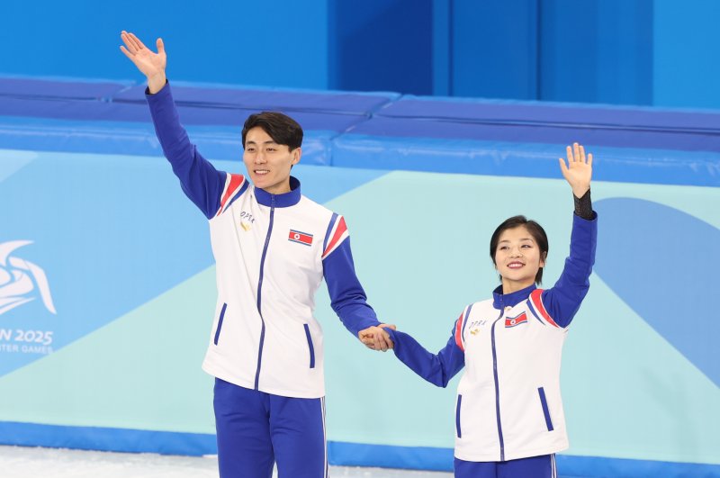 하얼빈 동계아시안게임 피겨 페어에서 은메달을 차지한 북한 렴대옥·한금철이 12일 중국 헤이룽장성 하얼빈 빙상훈련센터 다목적홀에서 열린 시상식에서 관중석을 향해 손인사를 하고 있다. 2025.2.12/뉴스1 ⓒ News1 이승배 기자