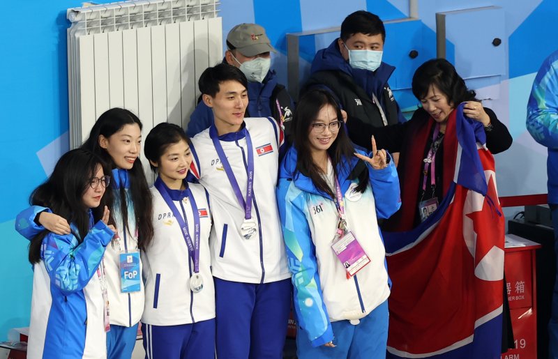 하얼빈 동계아시안게임 피겨 페어에서 은메달을 차지한 북한 렴대옥·한금철이 12일 중국 헤이룽장성 하얼빈 빙상훈련센터 다목적홀에서 열린 시상식을 마치고 자원봉사자들과 기념촬영하고 있다. 2025.2.12/뉴스1 ⓒ News1 이승배 기자