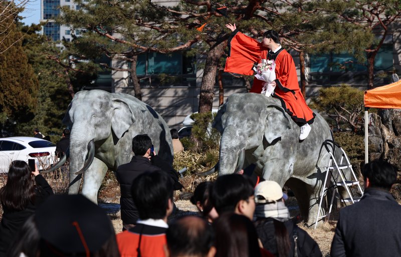 13일 서울 중구 장충동 동국대학교에서 열린 '2025년 봄 학위수여식'에서 졸업생들이 코끼리 동상에 올라타 기념촬영을 하고 있다. 2025.2.13/뉴스1 ⓒ News1 김도우 기자