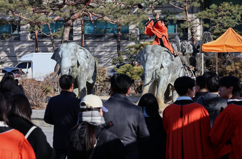 13일 서울 중구 장충동 동국대학교에서 열린 '2025년 봄 학위수여식'에서 졸업생들이 코끼리 동상에 올라타 기념촬영을 하고 있다. 2025.2.13/뉴스1 ⓒ News1 김도우 기자