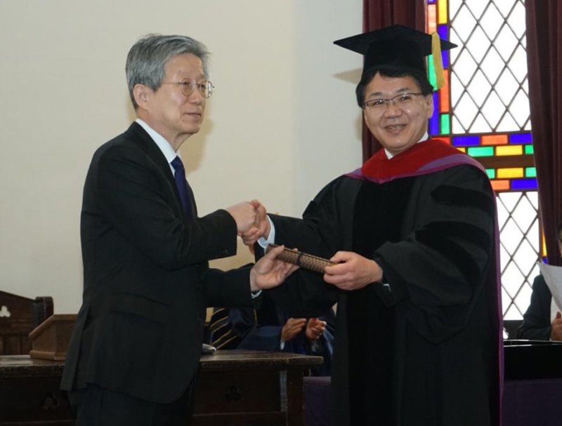 16일 일본 교토 도시샤대에서 열린 명예박사 학위 수여식에서 윤동주 시인의 조카 윤인석 성균관대 명예교수(왼쪽)와 고하라 가쓰히로 총장이 악수하고 있다. 연합뉴스.
