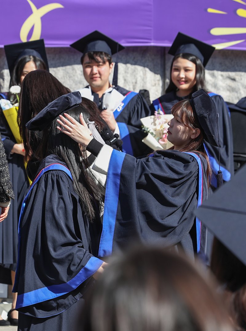 17일 서울 동작구 중앙대학교에서 열린 '2024학년도 전기 학위수여식'에 참석한 한 졸업생이 친구의 학사모를 바로 씌우고 있다. 2025.2.17/뉴스1 ⓒ News1 민경석 기자