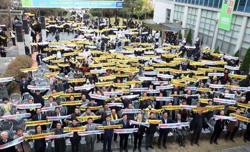 지난해 12월2일 전주시 전북특별자치도체육회관 야외광장에서 열린 '2036 하계올림픽 전북유치기원 체육인 한마음대회'에서 관계자들이 유치염원 문구가 적힌 타올을 흔들며 기념촬영을 하고 있다. 2024.12.2/뉴스1 ⓒ News1 유경석 기자