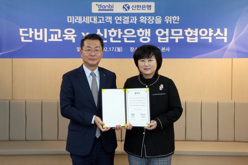 지난 17일 서울시 강남구 소재 단비교육 본사에서 열린 '미래세대고객 연결과 확장을 위한 업무협약식'에서 김재민 신한은행 영업추진1그룹 부행장(왼쪽)과 권영금 ㈜단비교육 대표이사가 기념 촬영을 하고 있다.