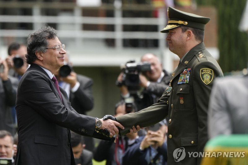 18일(현지시간) 신임 경찰청장과 악수하는 콜롬비아 대통령(왼쪽) (출처=연합뉴스)