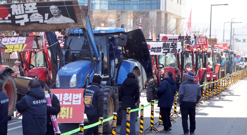 [세종=뉴시스] 강종민 기자 = 트랙터와 트럭 수십대를 몰고 상경행진에 나선 전국농민회총연맹 충남도연맹 농민들이 19일 세종시 정부세종청사 농림축산식품부 앞에서 결의대회를 열고 윤석열 대통령 체포와 구속, 개방 농정 철폐 등을 촉구하고 있다. 2024.12.19. ppkjm@newsis.com