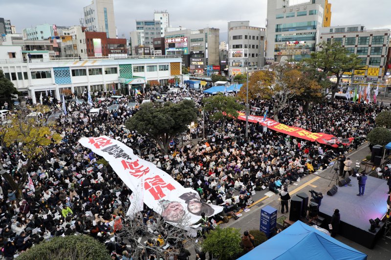 윤석열 대통령에 대한 두 번째 탄핵소추안 표결 직전인 14일 오후 5시10분쯤 제주시 이도2동 제주시청 앞 '윤석열 즉각 퇴진 요구 제주도민대회'에서 시민들이 윤석열 대통령과 김건희 여사의 얼굴이 그려진 현수막을 찢고 있다.2024.12.14./뉴스1 ⓒ News1 오미란 기자