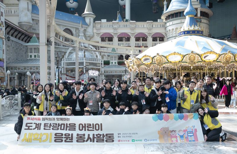 지난 18일 서울 송파구 롯데월드에서 열린 강원 삼척시 도계 탄광마을 아동 초청 문화 체험 프로그램에서 동서식품 임직원들과 아이들이 기념촬영을 하고 있다. 동서식품 제공