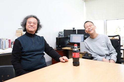 콜라 병 따주는 최성규 교수(왼쪽)와 장애인 제자 유장군씨 (출처=연합뉴스)