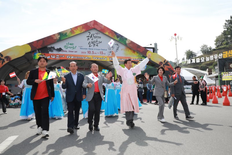 [금산=뉴시스] 박범인 금산군수 등이 2024 금산세계인삼축제에 참여한 관광객들을 맞이하고 있다. (사진= 금산군 제공) *재판매 및 DB 금지
