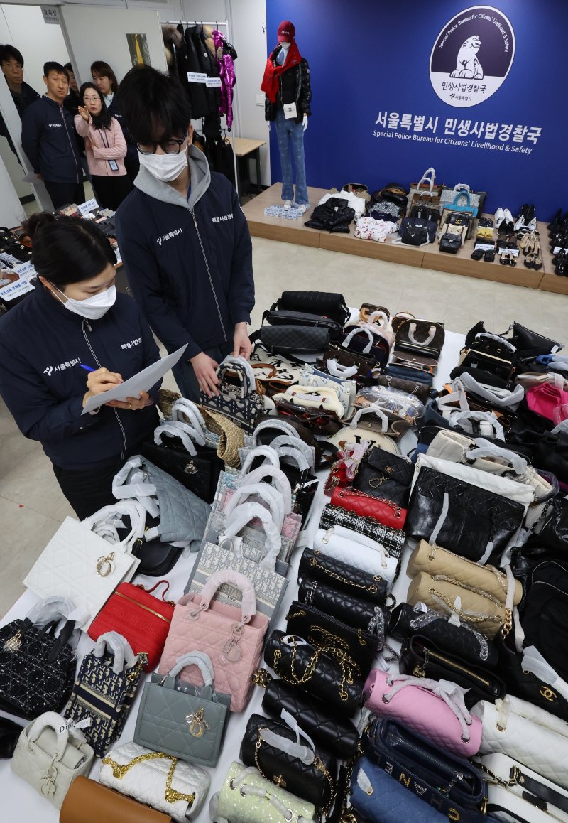 [서울=뉴시스] 김금보 기자 = 서울시 민생사법경찰국 경제수사과 직원들이 20일 오전 서울 중구 서울시청 남산 별관 민생사법경찰국에서 위조 명품 압수품을 정리하고 있다. 서울시청 민생사법경찰국은 명동 메인로드에서 6여년간 짝퉁 비밀매장을 운영한 일당 2명을 적발하고 정품가 38억원의 위조 명품을 압수했다. 2025.02.20. kgb@newsis.com