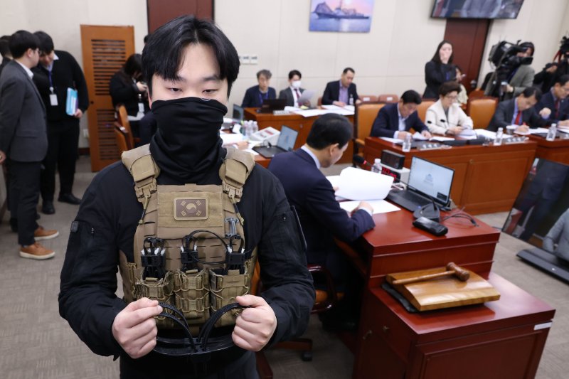 20일 오전 서울 여의도 국회에서 열린 국방위원회 전체회의에서 박선원 더불어민주당 의원실 비서관이 박 의원 질의를 위해 준비한 케이블타이 수갑을 들고 있다. 2025.2.20/뉴스1 ⓒ News1 이광호 기자