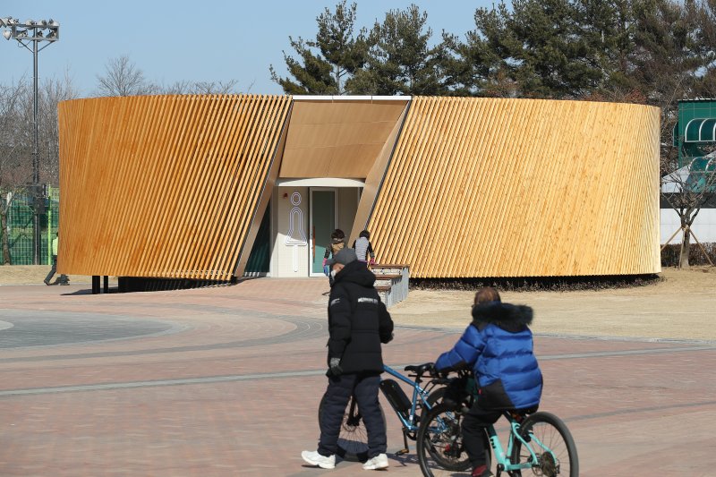 대구 수성구 수성못 상화동산 공중화장실이 최근 리모델링 공사를 마치고 개방됐다. 스페인 건축가의 설계를 바탕으로 예술적 요소를 강조한 이 화장실 리모델링 공사에 수성구가 예산 9억 원을 투입한 사실이 알려지며 논란이 일고 있다. 20일 수성못을 찾은 시민들이 화장실을 이용하고 있다. 2025.2.20/뉴스1 ⓒ News1 공정식 기자